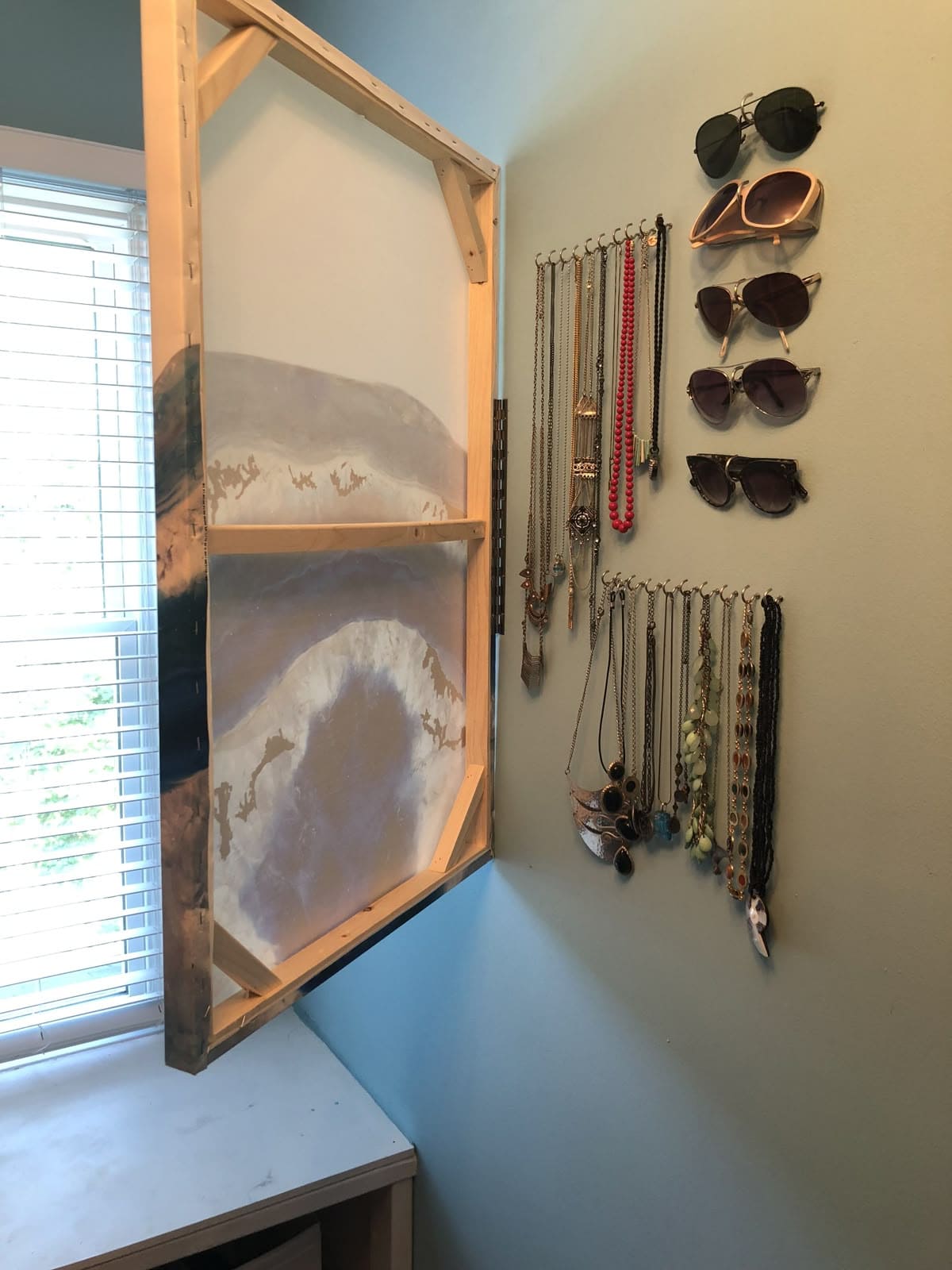 Disguised Jewelry and Sunglass Storage Behind Wall Art