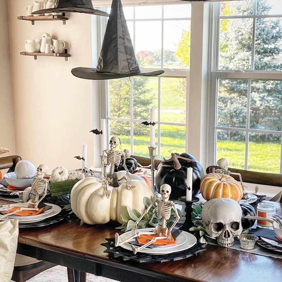 Skeleton-Themed Halloween Dining Table with Witch Hats and Pumpkins